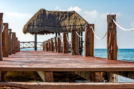Ein wunderschöner Strandsteg mit Palapa, am wunderschönen karibischen Meer an der Riviera Maya, diese Art von Anlegestelle ist typisch für große Resorts wie Grand Oasis, Bahia Principe...