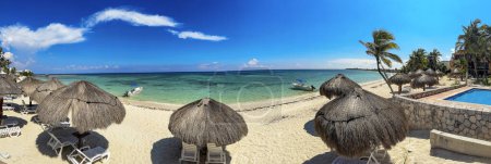 Panoramablick auf einen paradiesischen weißen Sandstrand mit dem Hintergrund des karibischen Meeres, unter warmer Sonne und grüner karibischer Vegetation.