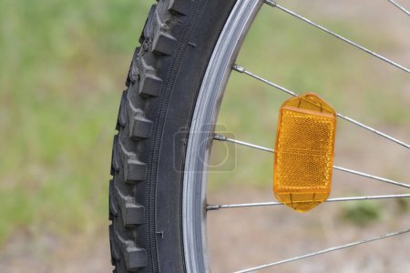 Photo for Orange reflector on the bicycle wheel. Safety device. Bike wheel reflector. - Royalty Free Image
