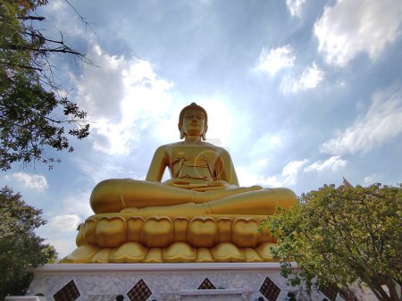 Téléchargez les photos : Grande statue de Bouddha doré (Phra Buddha Dhammakaya Thep Mongkol) dans le temple Wat Pak Nam Phasi Charoen. Lumière du soleil ciel et fond nuageux - en image libre de droit