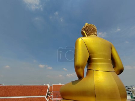 Téléchargez les photos : Arrière vue Golden big Buddha statue (Phra Buddha Dhammakaya Thep Mongkol) dans le temple Wat Pak Nam Phasi Charoen. Lumière du soleil ciel et fond nuageux - en image libre de droit