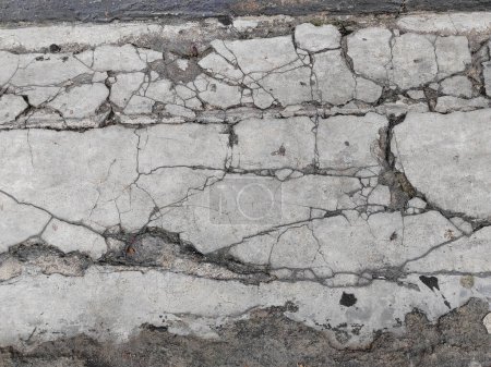 Terreno de hormigón agrietado roto en el suelo o la calle de mala construcción o terremoto