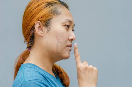 Photo for Asian woman doing silent gesture or no loud noise, concept shh - Royalty Free Image