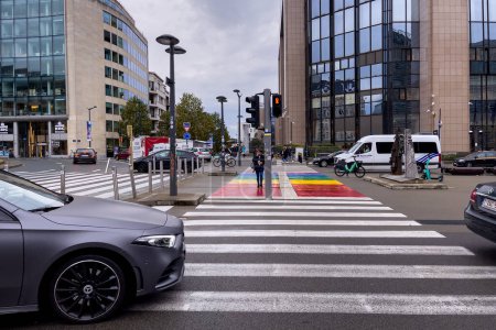 Téléchargez les photos : Voitures conduisant sur la route avec des lignes de croisement en zèbre aux couleurs arc-en-ciel à Bruxelles - en image libre de droit