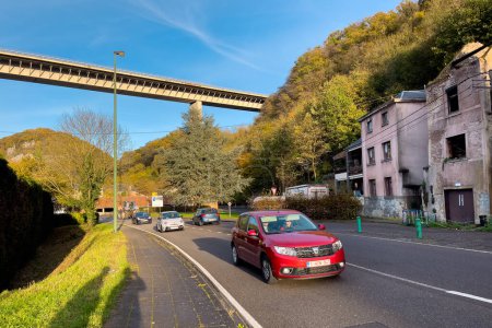 Photo for Cars driving on the road underneath the Charlemagne bridge in Dinant, Belgium - Royalty Free Image