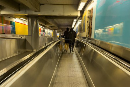 Téléchargez les photos : Voyageurs debout sur une passerelle mobile à l'intérieur d'une station de métro à Bruxelles - en image libre de droit