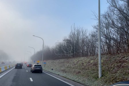 Téléchargez les photos : Cars driving on the highway during a foggy day in Belgium - en image libre de droit