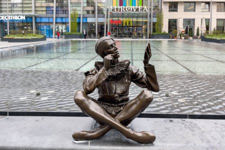 Téléchargez les photos : Statue en bronze d'une personne assise sur le bord de la fontaine devant le centre commercial Eurovea à Bratislava, Slovaquie - en image libre de droit