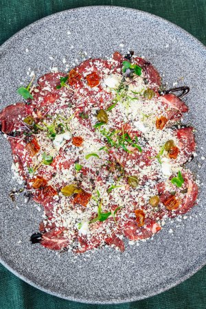 Thinly sliced veal carpaccio, drizzled with olive oil and topped with shaved Parmesan