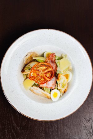 Téléchargez les photos : Salade César servie dans une assiette blanche dans un restaurant - en image libre de droit