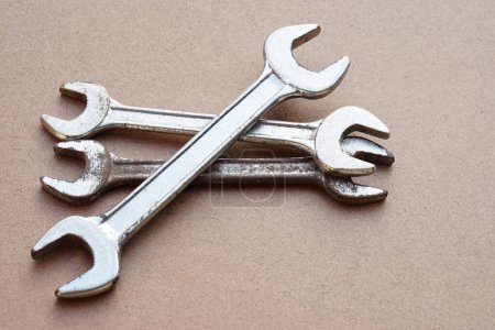 Photo for Three metal wrenches  isolated on brown. Concept, handyman, mechanic tools. Spanners. Equipment for fixing or repairing, renovation in daily life. - Royalty Free Image