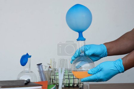 Téléchargez les photos : Student do science experiment, lab lesson, transparent bottles with inflated balloons on top of bottle. The experiment about air or gas reaction by using chemical substances. Education Science subject - en image libre de droit