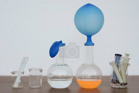 Téléchargez les photos : Expérience scientifique, ballon gonflé bleu sur le dessus d'une bouteille d'essai transparente. L'expérience sur la réaction de l'air ou du gaz en utilisant du bicarbonate de soude et du vinaigre. - en image libre de droit