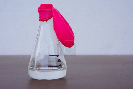 Téléchargez les photos : Science experiment, flat pink balloon with no air on top of transparent test bottle. First step of the experiment about air or gas reaction.by using baking soda and vinegar.Concept,  Science Education - en image libre de droit