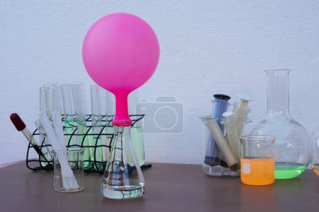 Téléchargez les photos : Expérience scientifique, ballon gonflé rose sur le dessus d'une bouteille d'essai transparente. L'expérience sur la réaction de l'air ou du gaz en utilisant du bicarbonate de soude et du vinaigre. - en image libre de droit