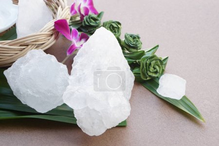 Kristallklare Aluminiumsteine oder Kaliumalaun, verziert mit Blumen und Blättern. Nützlich für Schönheits- und Wellnessbehandlungen. Körpergeruch unter den Achseln als Deo behandeln und Wasser klar machen. 