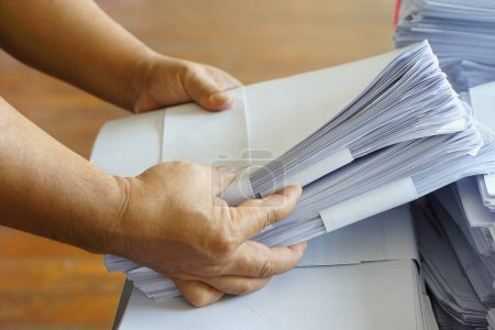 Photo for Closeup hands hold stack of used paper to recycle or combine to use next time to print out both sides of paper. Concept, eco friendly activity for environment, reuse paper. - Royalty Free Image