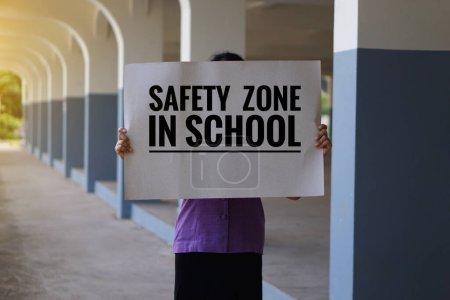 Mann hält Plakatpapier mit dem Wort Sicherheitszone in der Schule. Konzept, Unterschriftenkampagne, Protest für ein Ende der Gewalt, ernsthafte Bestrafung durch Lehrer, Drohungen oder Mobbing an Schulen.  