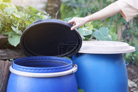 Photo for Closeup hand hold lid to cover water bucket to protect from mosquito to breed inside or other  insects or dust go into water. Concept, campaign to stop mosquitoes cycle to lay eggs in water container - Royalty Free Image
