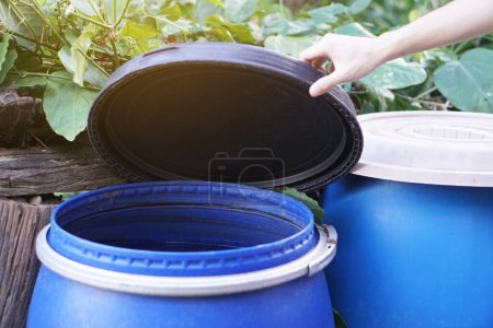 Photo for Closeup hand hold lid to cover water bucket to protect from mosquito to breed inside or other  insects or dust go into water. Concept, campaign to stop mosquitoes cycle to lay eggs in water container - Royalty Free Image