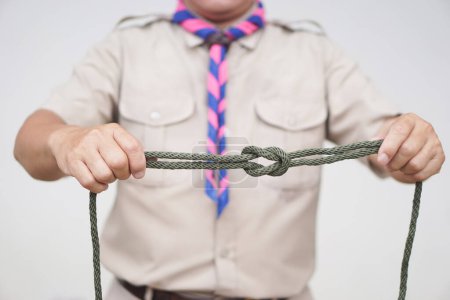 Photo for Tying rope knot pattern, demonstrated by scout teacher trainer. Concept, useful tying knot for many purposes in daily life. Tying knot rope teaching aid. Life skills with rope. - Royalty Free Image
