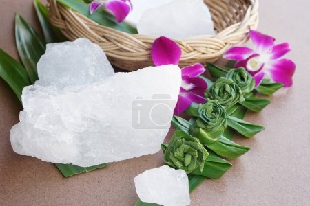 Piedras de alumbre cristalinas o alumbre potásico decorado con flores y hojas. Útil para tratamientos de belleza y spa. Uso para tratar el olor corporal debajo de las axilas como desodorante y hacer que el agua clara.
