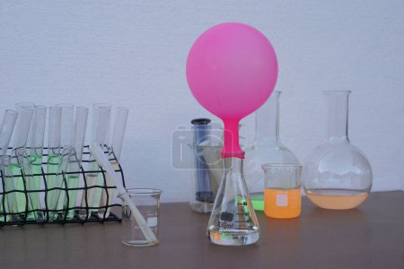 Wissenschaftliches Experiment, rosa aufgeblasener Ballon auf transparenter Testflasche. Das Experiment zur Luft- oder Gasreaktion mit Backpulver und Essig.