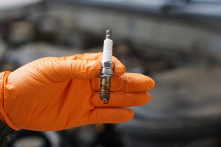 Close up mechanic hand hold old spark plug, spare part of car engine. Concept, machine maintenance, fix, repair, check or diagnose automobile problems by engine specialist.     