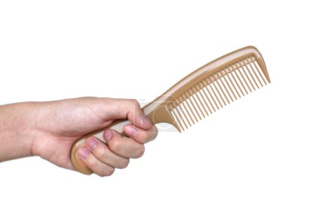 Close up hand hold brown comb isolated on white background.  Concept, Hair beauty tool for hairstyle design in daily life. Hair care equipment.         