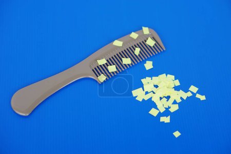 Comb and small pieces of paper. Equipment, prepared to do experiment about static electricity. Blue background. Concept, Science lesson, fun and easy experiment. Education. Teaching aids.