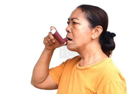 Seniorin benutzt braunes Asthma-Inhalator zur Linderung von Asthma. Konzept, Gesundheitsversorgung zu Hause. Pharmazeutische Produkte zur Behandlung von Asthma oder COPD. Anwendung auf Rezept des Arztes.   