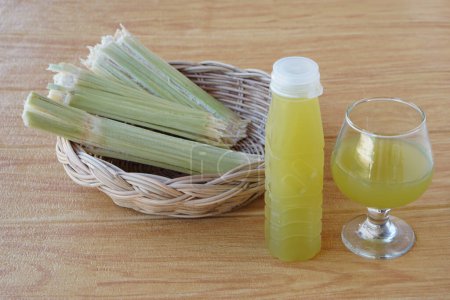 Bottles of fresh sugar cane juice. and bagasse after squeezing for a drink in basket. Concept, healthy natural beverage made from agriculture crop. Homemade drinks, has medicinal , herbal properties  