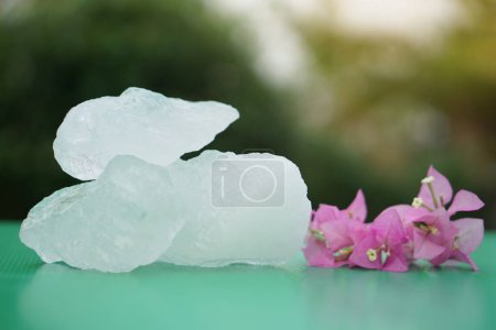 Photo for Crystal clear alum stones or Potassium alum decorated with flowers.  Useful for beauty and spa treatment. Use to treat body odor under the armpits as deodorant and make water clear. - Royalty Free Image