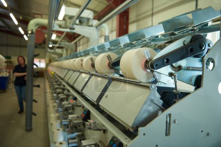 Foto de Máquinas de tejido de algodón de metal de acero inoxidable industrial, tejido de máquina de algodón para la industria de la moda y los textiles. Tejido de hilo textil tradicional - Imagen libre de derechos