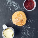 A beautiful gourmet scone served with tea and coffee, strawberry jam and clotted cream. traditional british food. Cackes and see treats