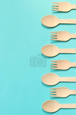 Foto de Tenedores y cucharas desechables de madera sobre un fondo azul, vista superior. Ecológico utensilios de cocina desechables, espacio para copiar. Puesta plana - Imagen libre de derechos