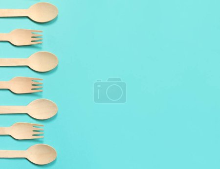 Foto de Tenedores y cucharas desechables de madera sobre un fondo azul, vista superior. Ecológico utensilios de cocina desechables, espacio para copiar. Puesta plana - Imagen libre de derechos