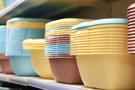 Photo for Colored pelvis on a shelf in a supermarket. Square polypropylene basins folded one to one, selective focus. Home goods in the store - Royalty Free Image