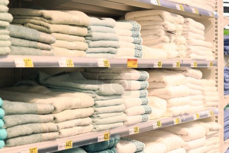 Photo for Kyiv, Ukraine - 07 of July 2023: Shelves with towels of different colors in the mall. Home textile beautiful towels are stacked on a shelf in a store - Royalty Free Image