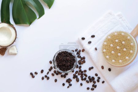 Photo for Spa self care concept. Flat lay composition of coffee scrub, massage brush, white towel, coffee beans, coconut and monstera leaf on white background. Copy space, top view. Spa treatment. - Royalty Free Image