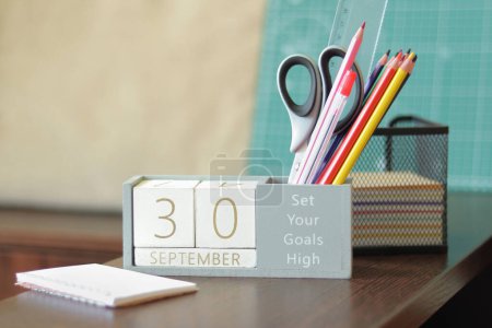 Photo for 30 September. Image of september 30 wooden calendar on desktop. Autumn day. Back to school. Pencils and paints, stationery - Royalty Free Image