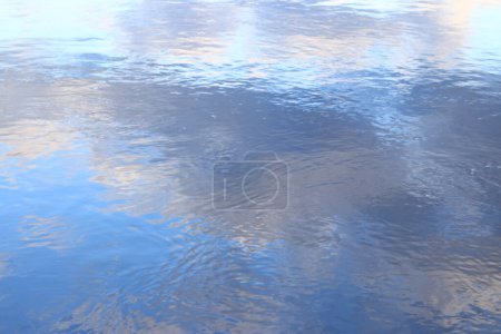 Reflet des nuages dans l'eau. La surface de l'eau dans un lac, une rivière ou une carrière inondée. Ondulations sur l'eau. Belle couleur d'eau. Contexte naturel