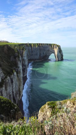 Cliffs, landscape along the Falaise d'Aval, view of the La Manche. Etretat, Normandy, France, English Channel. Natural rocks, coast. Rocks of the village of Etretat in spring in cloudy weather