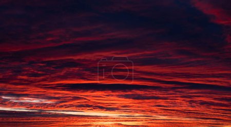 Foto de El cielo rojo anaranjado oscuro está fuera de foco. Cielo dramático con nubes oscuras. Puesta de sol. Banner. Ruido. - Imagen libre de derechos