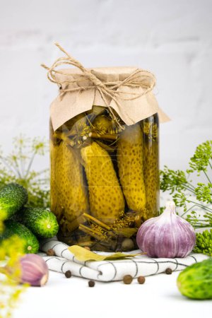 Téléchargez les photos : Homemade pickled cucumbers in a jar on the kitchen table. Close-up. - en image libre de droit