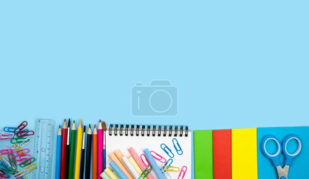 School composition with colorful school supplies on blue background. Back top school concept. Top view. Copy space.