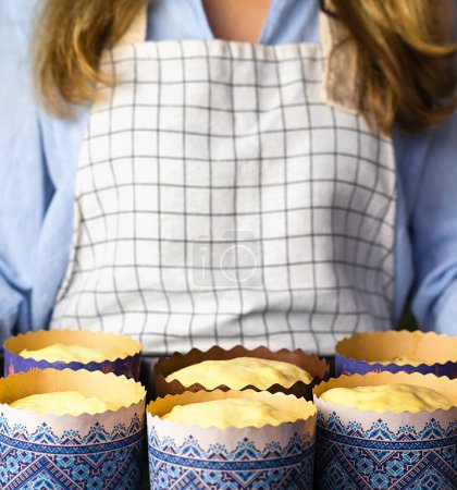Frau hält Backblech mit saurem Teig zum Osterbacken in Papierform. Hausgemachte Kuchen zu Ostern. Nahaufnahme. Selektiver Fokus.