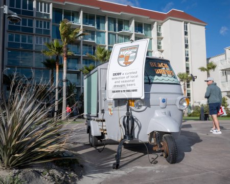 Foto de San Diego, CA. 5 de abril de 2024. Coronado beach electric car mobile brewery Beach Brews. Construido en 1888, este hotel es una atracción turística histórica en la isla de Coronado. - Imagen libre de derechos