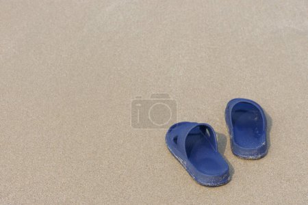 Foto de 1 par de sandalias en la playa de arena. - Imagen libre de derechos