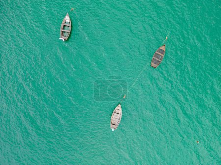 Téléchargez les photos : Une vue imprenable sur un bateau en bois sur le lac entouré par le paysage verdoyant d'une perspective de vue de dessus. - en image libre de droit